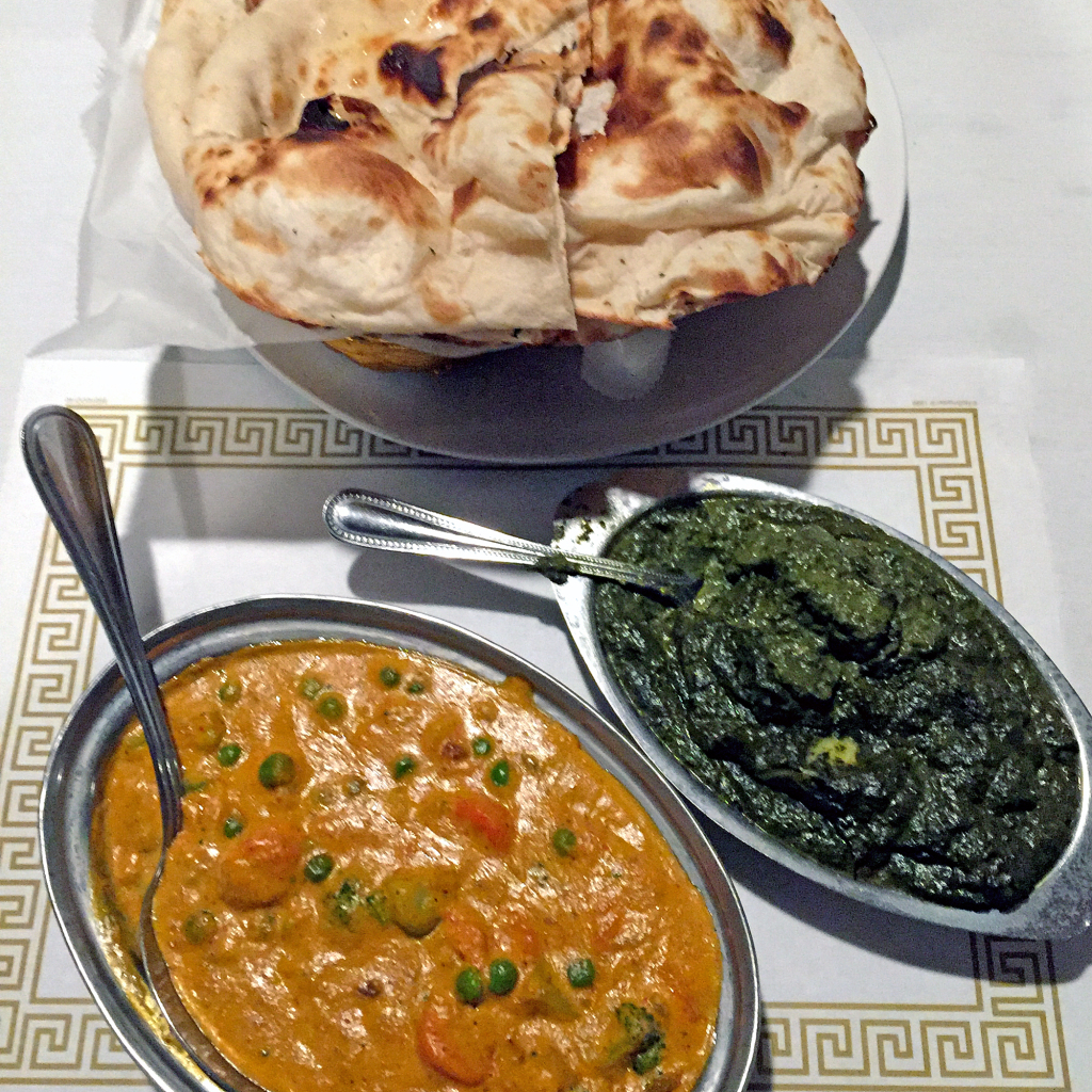 From the top, three Indian breads, spinach aloo saag and veggie korma at Taj Palace