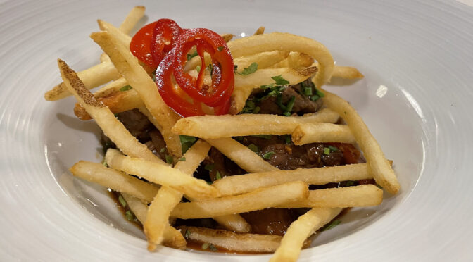 A steak with a Peruvian accent, lomo saltado at the old Anoosh Bistro was a beefy appetizer (topped with crisp fries and zippy red peppers) big enough to serve as a main dish.